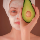 Femme avec masque blanc tenant un fruit vert