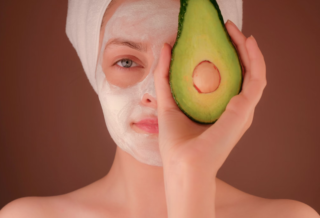 Femme avec masque blanc tenant un fruit vert