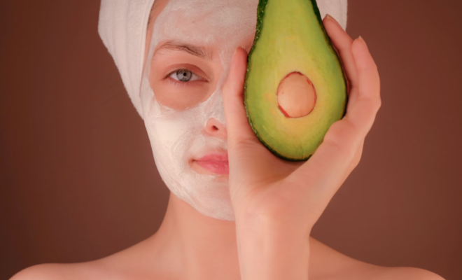 Femme avec masque blanc tenant un fruit vert